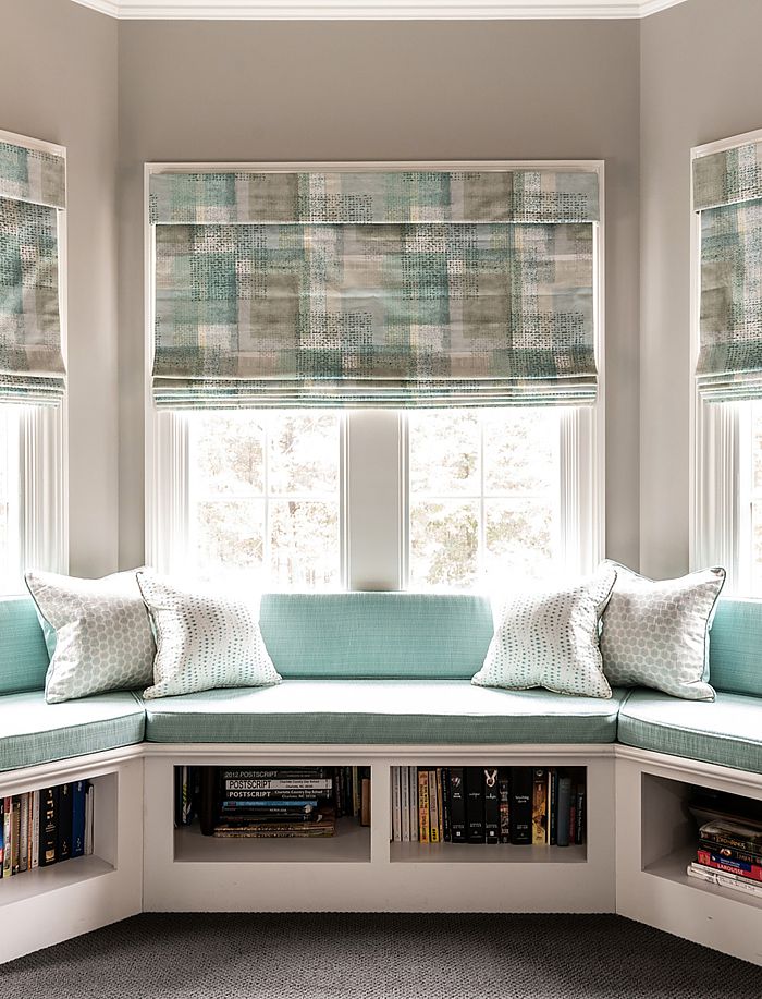 Seen here is a lovely bay window with custom roman shades and seat cushions.